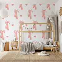 Repeating motif of pink shoes, hearts and bows on a white wallpaper.