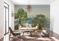 Striped zebras feed on a grassy patch in the Safari River Oasis wall mural with a lion behind them.