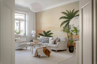 Layered coral and lavender hills behind green foliage in a tropical wall mural for living room.
