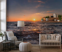 Ocean sunset wall mural across a nursery accent wall in calm amber light