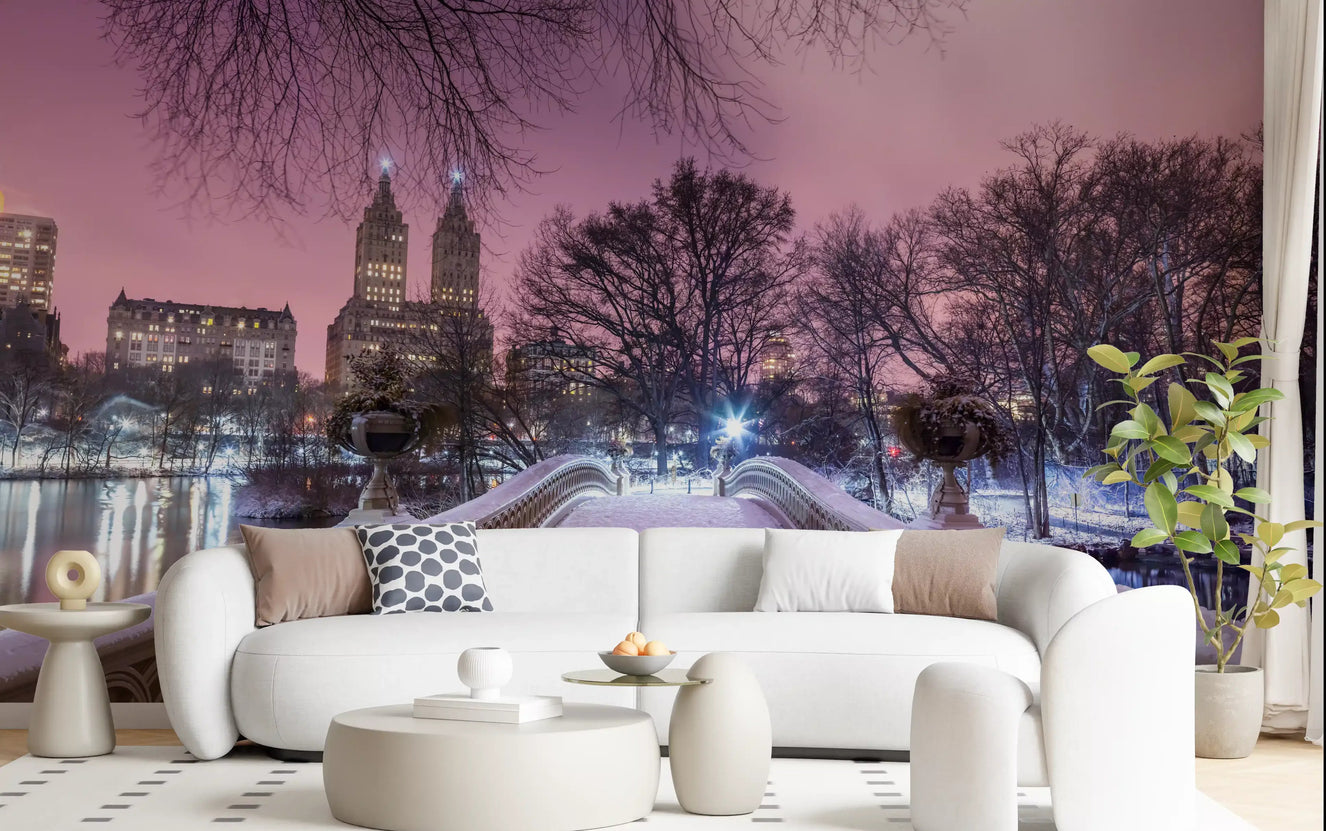 ow Bridge wall mural showing snowy Central Park at winter dusk under a pink sky in living room.