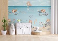 Nursery wall mural with Grey dolphin swimming past a mermaid near pink and green coral., GD10169