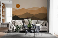 Layered mountain landscape wall mural in tan, umber and near-black with a soft burnt sun., GD10293