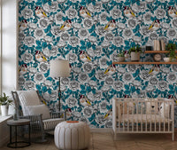 European goldfinch birds perched among white roses on teal leaf wallpaper.
