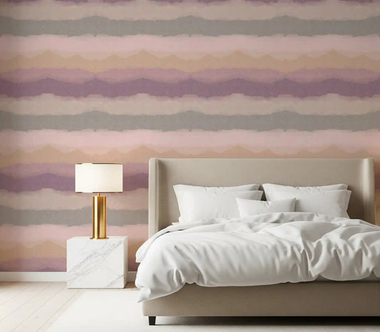 Painted horizon gradient wallpaper with pink and ochre bands in a bedroom.