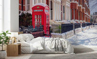 Red telephone booth wall mural against snow-covered brick buildings in bedroom., GD10423