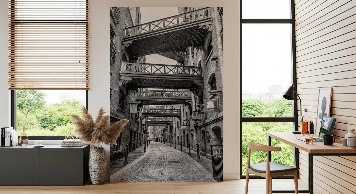 Dark metal bollards along the cobblestone lane in this wall mural., GD10447