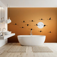 Amber sky wall mural featuring flamingos soaring past a glowing white sun., GD10459