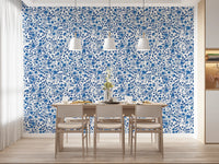 Cobalt blue rose wallpaper with layered leaves and curving stems in dining room.
