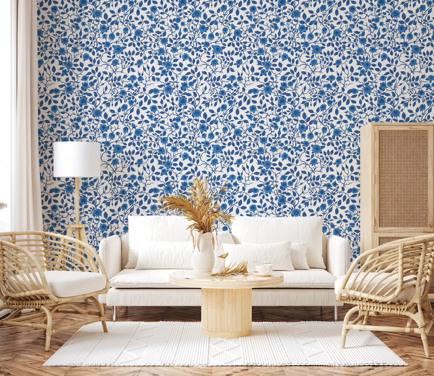 Floral repeat pattern wallpaper with blue roses and pointed blue leaves.