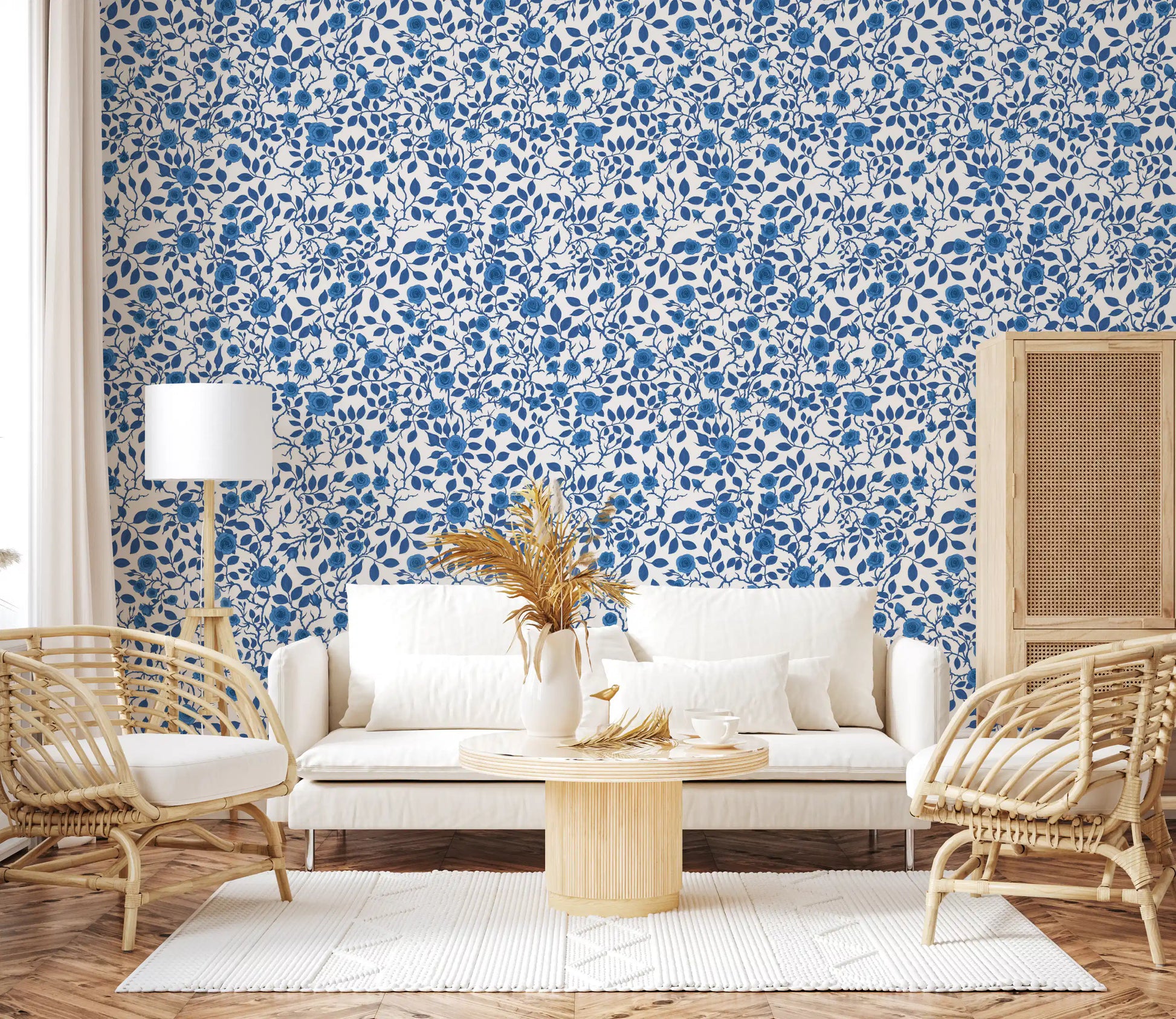 Floral repeat pattern wallpaper with blue roses and pointed blue leaves.