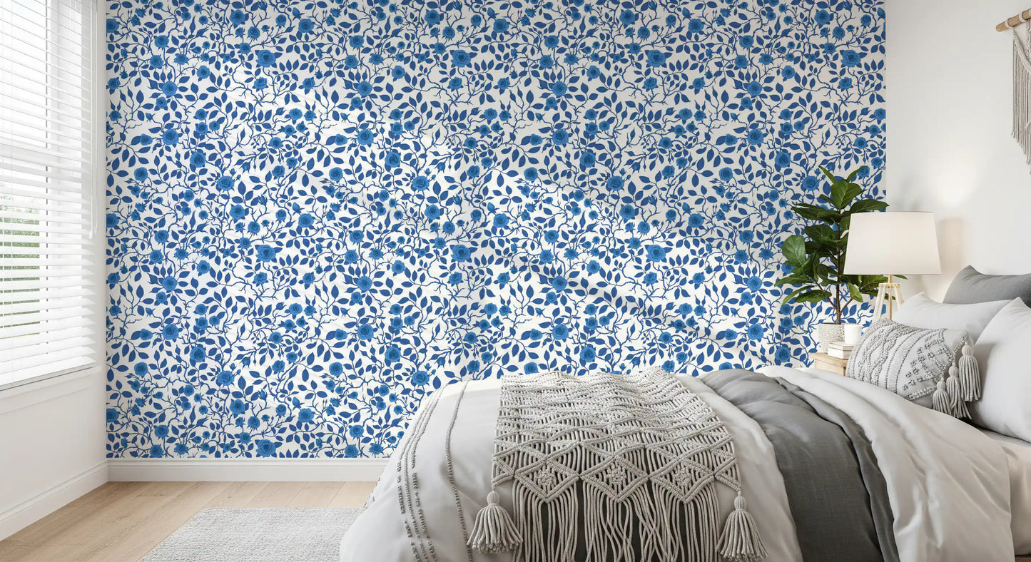 Bedroom wallpaper with blue roses and winding vine pattern on white.