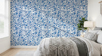 Bedroom wallpaper with blue roses and winding vine pattern on white.