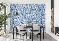 White background wallpaper with dense blue rose vine pattern.