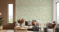 Rose vine wallpaper with green thorny stems and pink buds on cream backdrop.