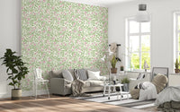 Blush pink wallpaper with rose vine clusters and sage green foliage.