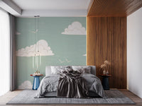 Large and small white clouds scattered across sage wall mural in bedroom.