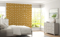 Warm mustard wall mural with scattered cream seed shapes in bedroom., GD10570