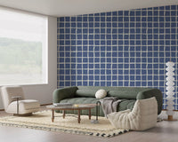 Mid century blue grid pattern wallpaper in a living room space.