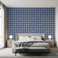 Tonal blue wavy grid wallpaper with organic line spacing in bedroom.