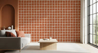 Burnt orange and off-white grid pattern wallpaper in bright seating area.