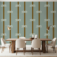 White sailor knots on sage green and olive striped wallpaper in dining room.