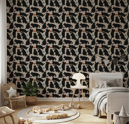Kids room with playful black cats and yarn balls wallpaper on beige background.