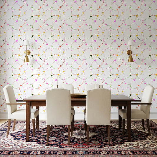 Dining room with colourful heart and dotted trail pattern wallpaper in multicolour palette.