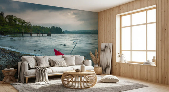 Red umbrella resting on pebble shore of a misty grey lake mural in hallway GD10942