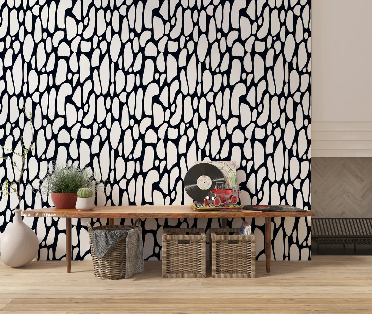 Organic monochrome pebble wallpaper above a wood console table with plants GD12223