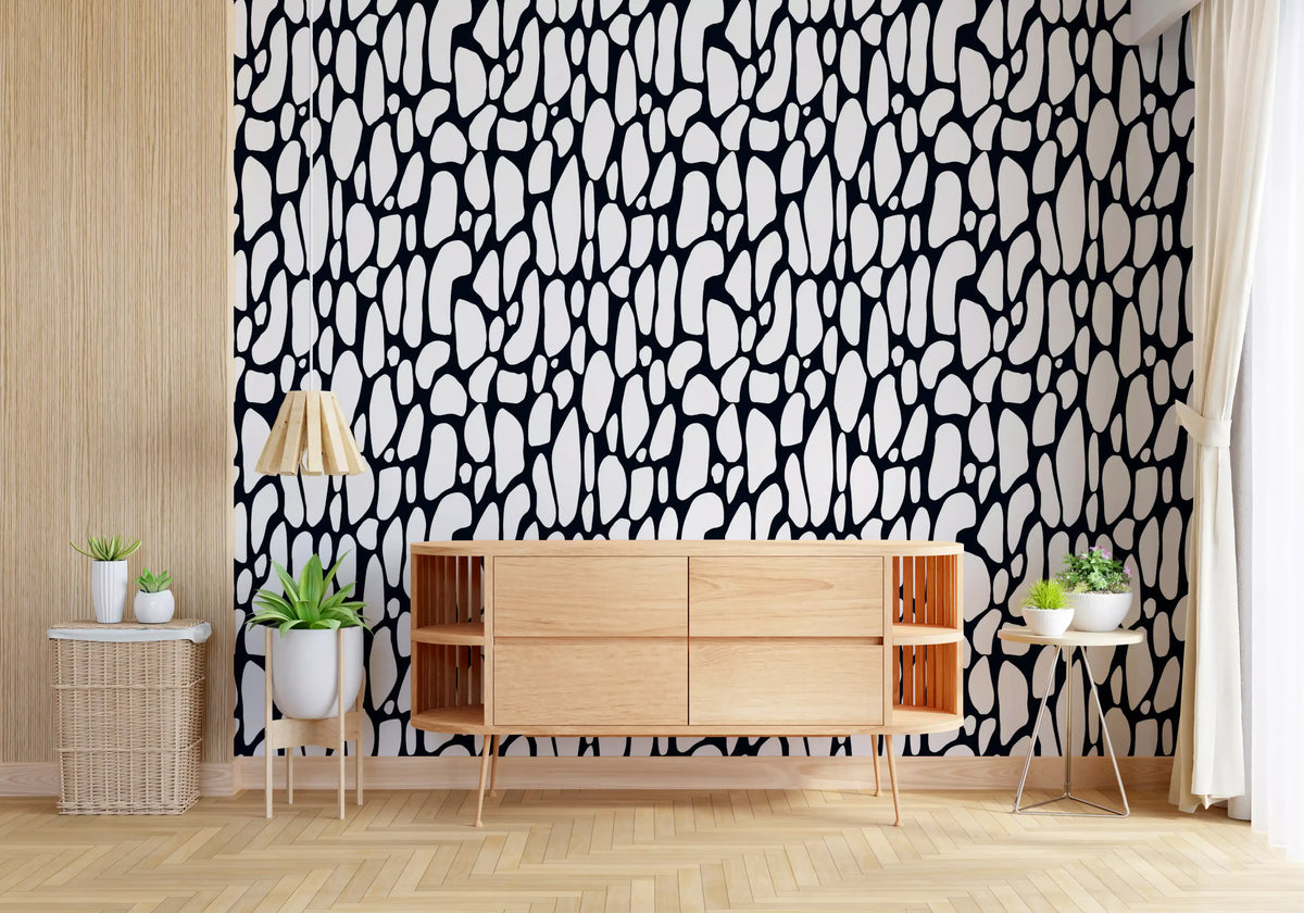Monochrome pebble wallpaper behind a wooden sideboard in a bright room GD12223