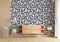 Monochrome pebble wallpaper behind a wooden sideboard in a bright room GD12223