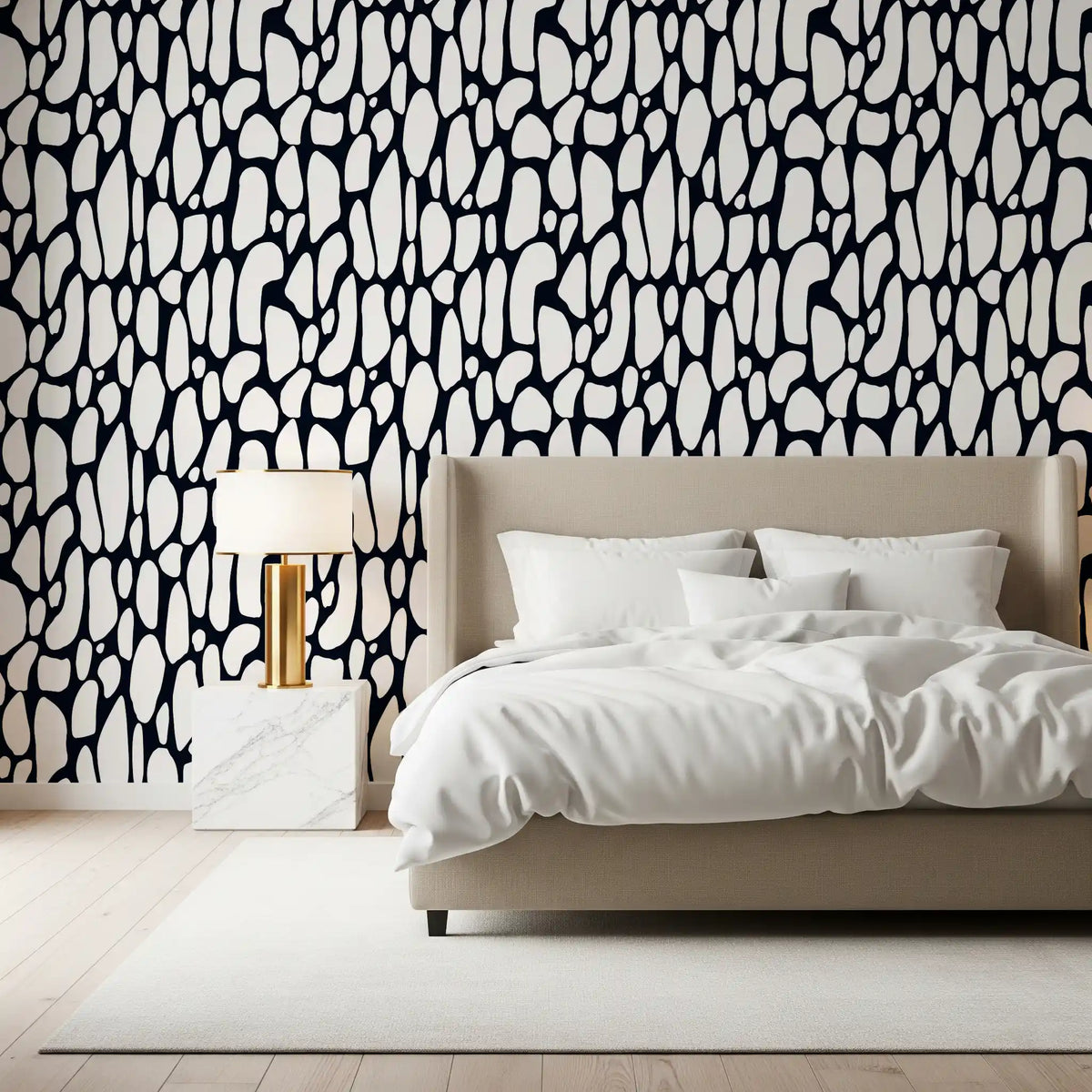Monochrome pebble abstract wallpaper behind a beige upholstered bed in a bedroom GD12223