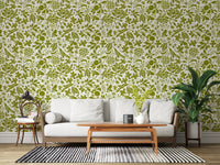 Green botanical wallpaper in a living room behind a white sofa and wood table GD12255