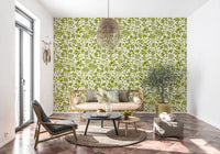 Sage botanical wallpaper in a sunny living room with a gold framed sofa GD12255