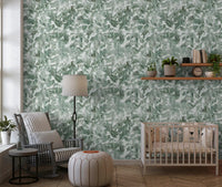 Soft green leaf wallpaper in a nursery with a cot GD12325