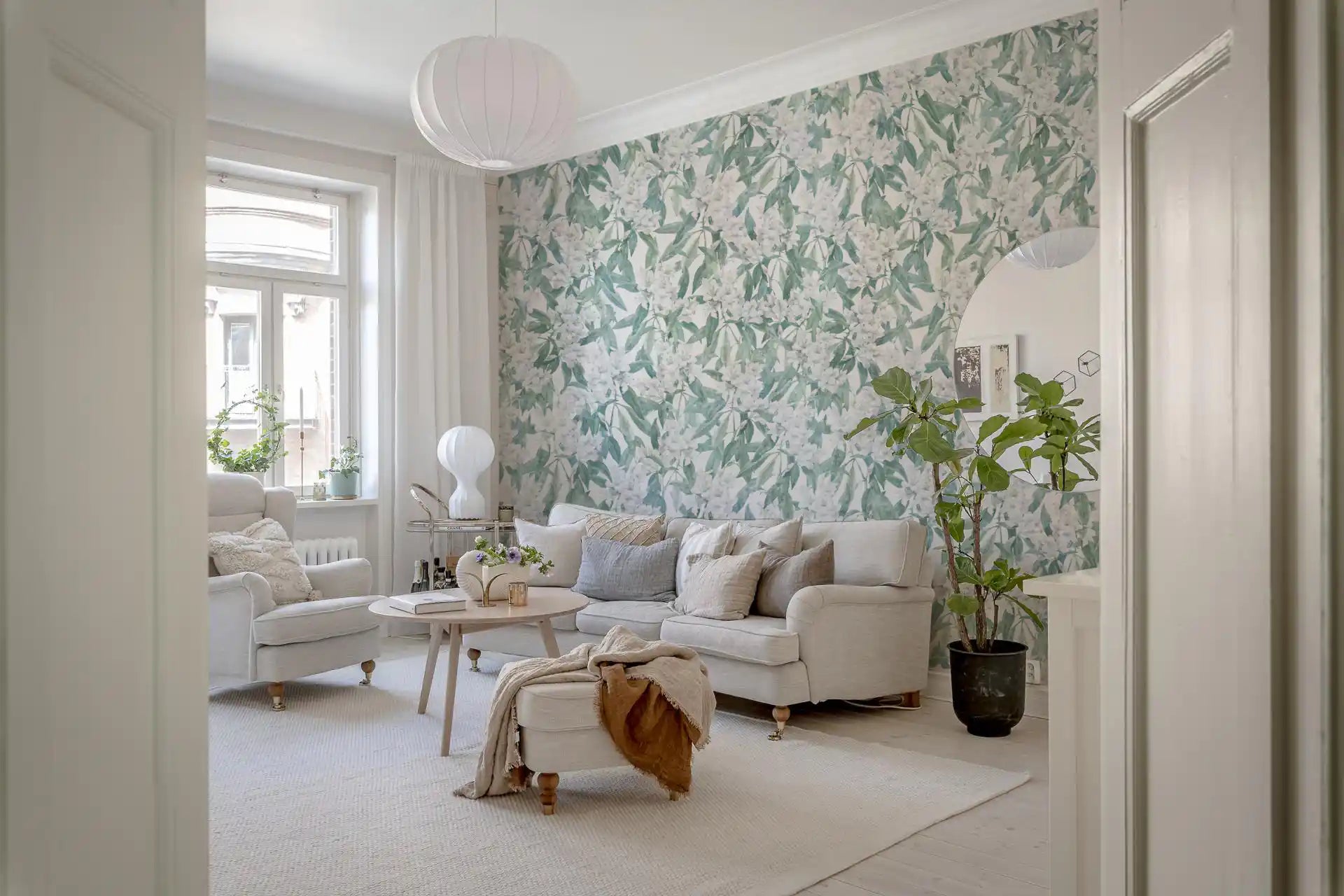 Green leaf trail wallpaper in a bright living room with a white sofa GD12360