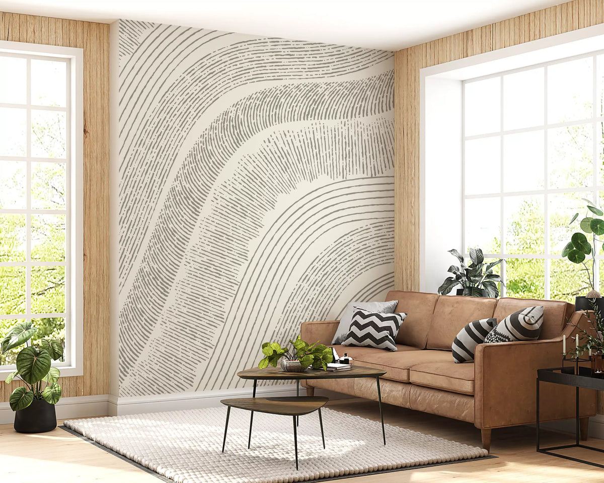 Cream etched mural in a living room with a tan leather sofa and plants GD12473