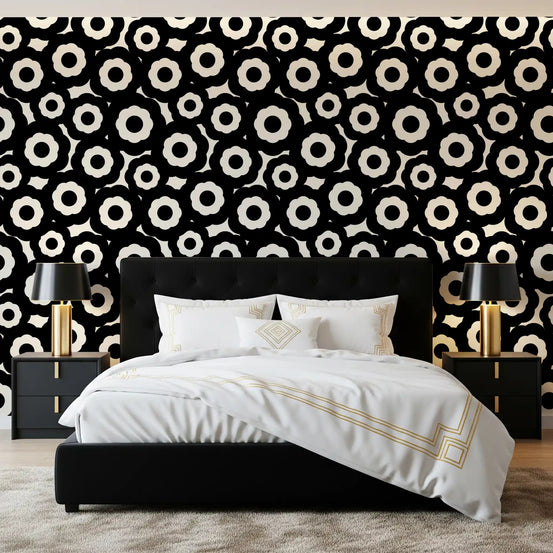 Modernist cream and black flower wallpaper behind a dark upholstered bed GD12495