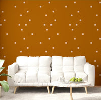 Warm terracotta polka dot pattern wallpaper on a living room feature wall.
