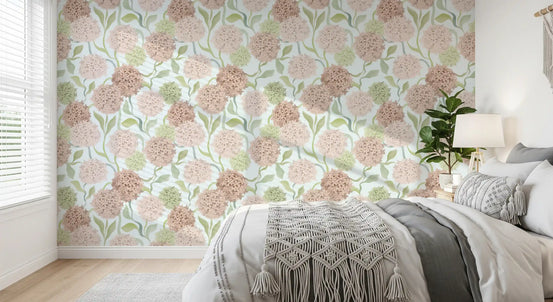 Pink and green floral watercolour wallpaper in a cosy bedroom with a grey bed GD12712