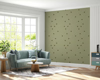 Retro polka dot wallpaper with loose olive shapes on soft green surface.