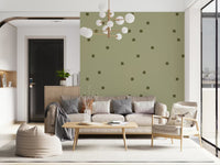Living room wallpaper showing sage green base with scattered olive dots.