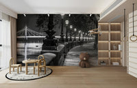 The lights from the bridge and lamps reflect on the water.

