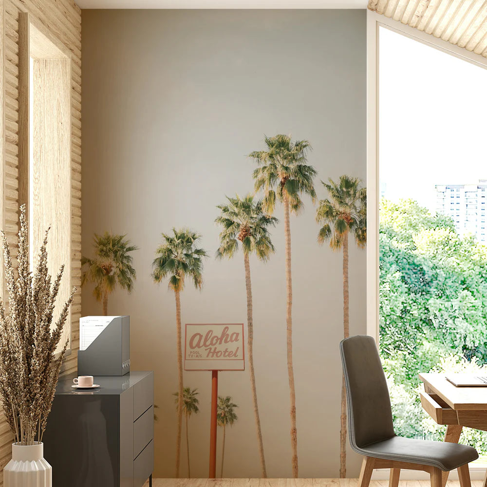 Room interior with palm tree mural and 'Aloha Inn Hotel' sign.