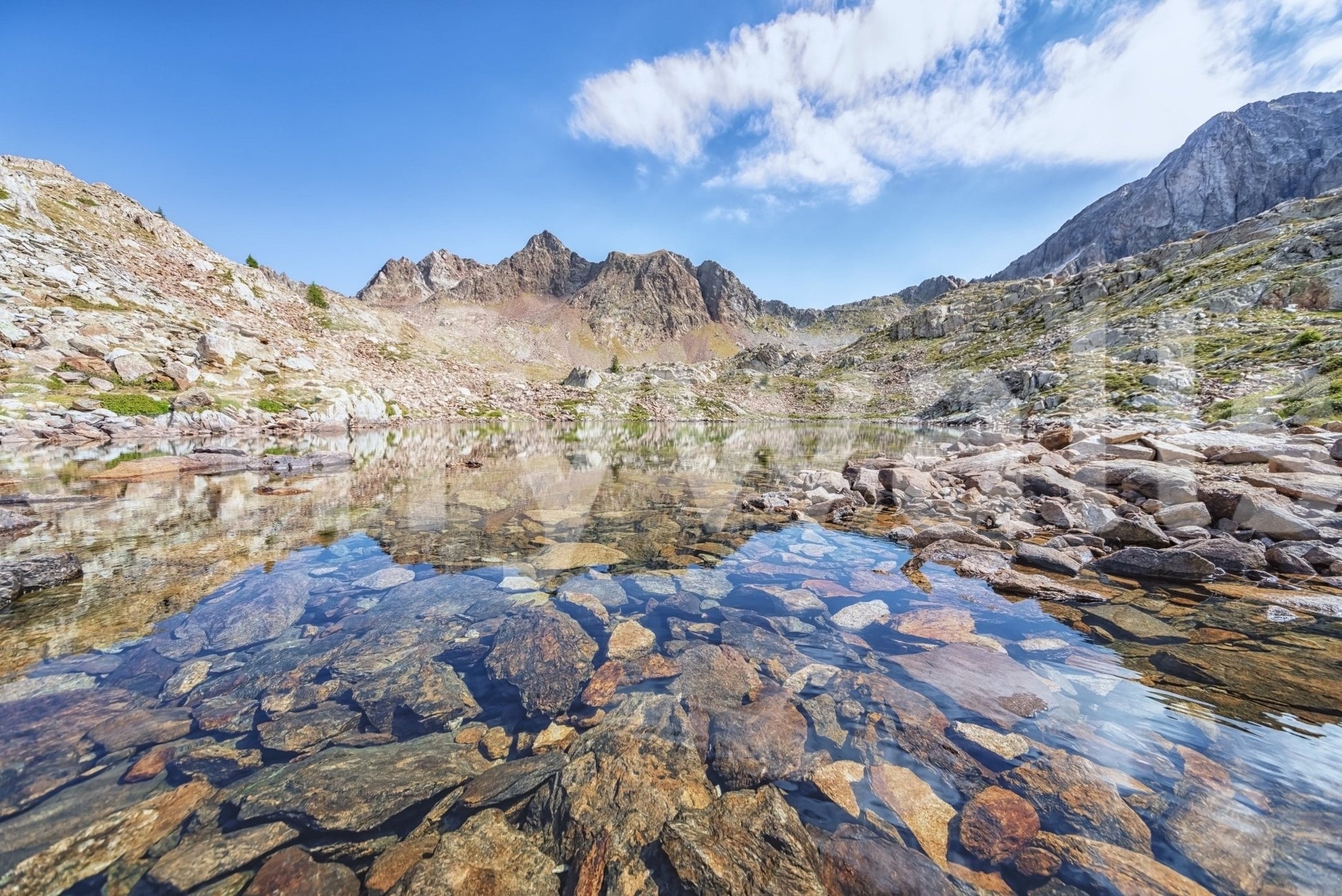 Alpine Serenity wall mural with rocky lake foreground and bright mountain reflections