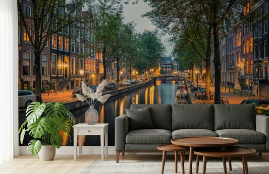 A cozy lounge framed by Amsterdam Canal Lights Wall Mural and glowing canal reflections
