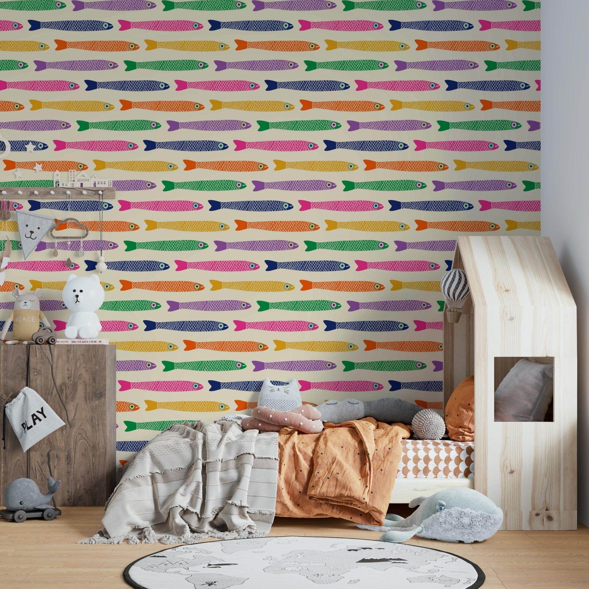 Anchovies fish in rainbow shades on a cream wallpaper backdrop

