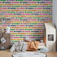 Anchovies fish in rainbow shades on a cream wallpaper backdrop

