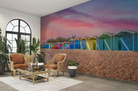 A close-up of the vibrant beach huts under a dramatic sky.

